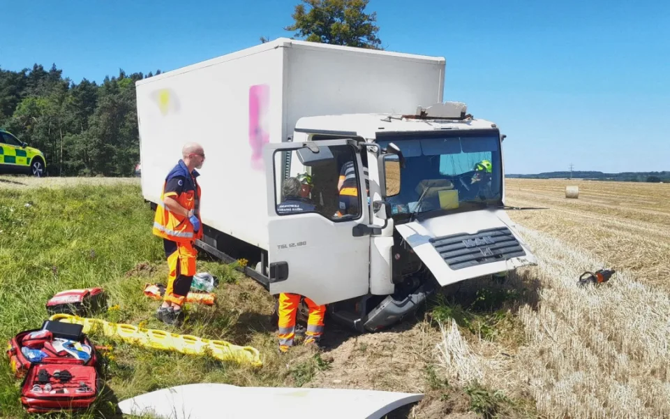 Při srážce osobáku s náklaďákem se těžce zranili čtyři lidé. Vozidla skončila v příkopu daleko od sebe