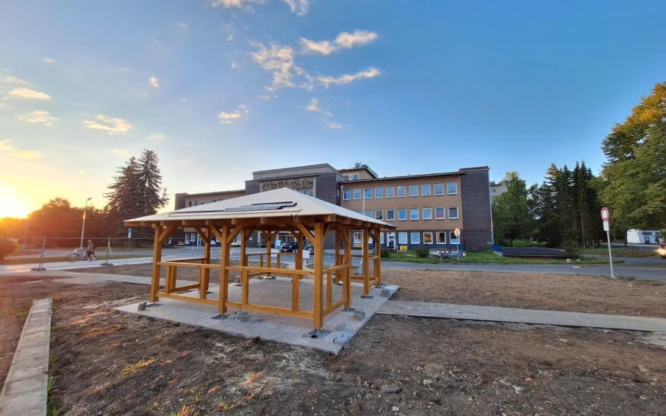 Nevzhledná travnatá plocha před nemocnicí se mění v park s altánkem